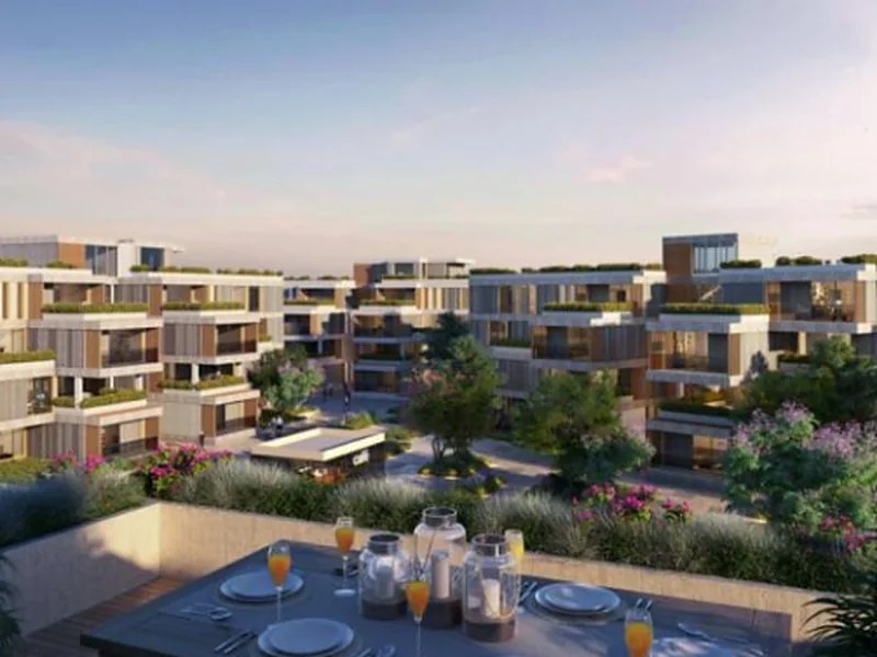 Rendering of VYE by SODIC in New Zayed — terraced residential buildings and gardens seen from a rooftop terrace at sunset